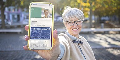 Foto Frau zeigt digitale MVHS-Card auf Smartphone